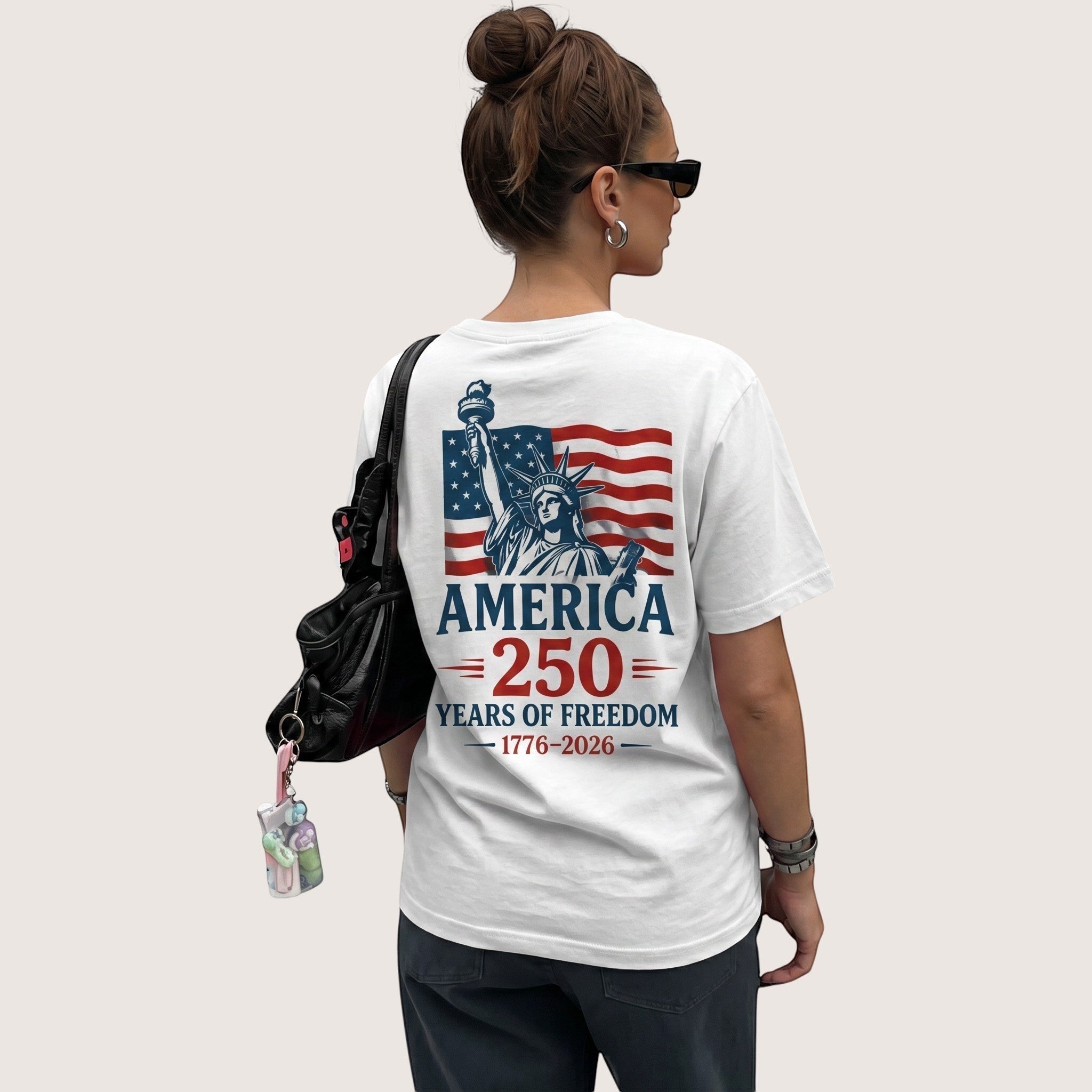 TrendyShift.Com white cotton unisex t-shirt featuring a Statue of Liberty and American flag 250th anniversary graphic.