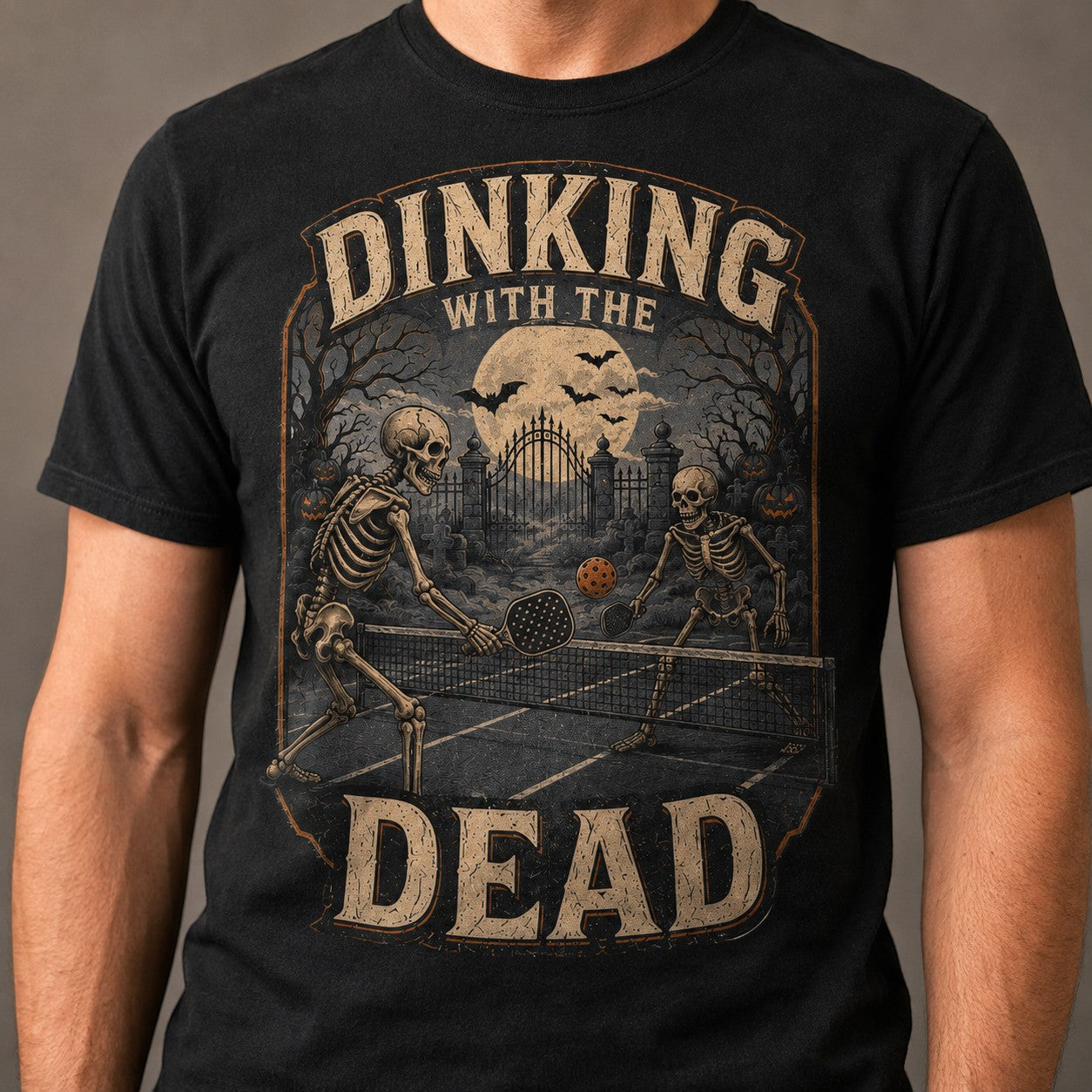 WearTheJoke.com black cotton t-shirt featuring a vintage skeleton pickleball graphic with a spooky Halloween theme.